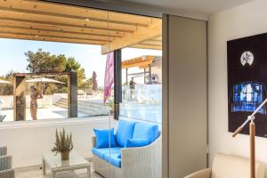 a living room with a blue couch in front of a window at Hotel Levante in Es Pujols