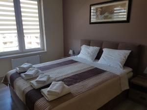 sypialnia z dużym łóżkiem i ręcznikami na nim w obiekcie Apartament Bałtyk Polanki Park, basen, sauna, fitness, sala zabaw dla dzieci w Kołobrzegu