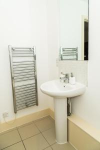 a bathroom with a white sink and a mirror at Serviced Apartment In Liverpool City Centre - Free Parking - Balcony - by Happy Days in Liverpool