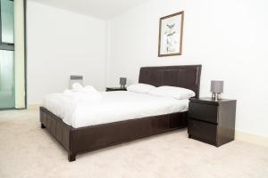 a bedroom with a large bed and two night stands at Serviced Apartment In Liverpool City Centre - Free Parking - Balcony - by Happy Days in Liverpool