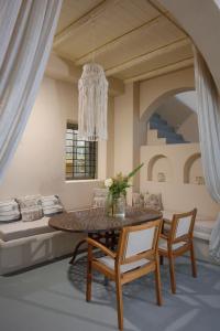 a dining room with a table and chairs and a couch at THE A COLLECTION by K&K in Oia +135 photos