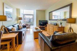 a living room with a couch and a tv at City Centre Skeldergate 2 Bed Apartment with Parking in York