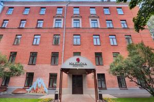 un bâtiment en briques rouges avec un panneau devant lui dans l'établissement Maxima Irbis Hotel, à Moscou