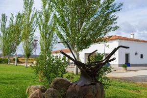 a statue of a tree on a rock in front of a building at Hotel Rural Arroyo la Plata by Bossh Hotels in Jerez de los Caballeros