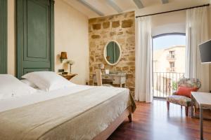 una camera con un letto e una sedia e una finestra di YIT La Casona del Arco a Baeza