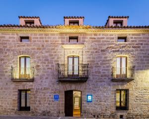 Un gran edificio de piedra con ventanas y una puerta. en YIT La Casona del Arco, en Baeza 37 fotos más