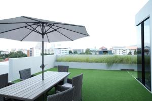 a table and chairs with an umbrella on a roof at Maleesa Place Hua Hin in Hua Hin