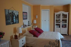 een slaapkamer met een bed met rode kussens erop bij La Gallina Bianca in Feucherolles