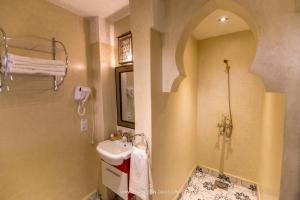 a bathroom with a sink and a mirror and a shower at Ksar Sultan Dades in Boumalne Dades