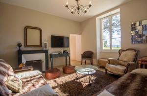 een woonkamer met een bank en een open haard bij Villa des Mimosas in Muzillac