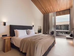 a bedroom with a large bed and a large window at Contessina Suites & Spa - Adults Only in Tsilivi