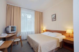 una camera d'albergo con letto, scrivania e TV di Maxima Irbis Hotel a Mosca