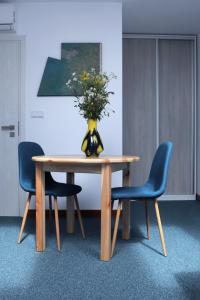 einen Tisch mit zwei Stühlen und eine Vase mit Blumen darauf in der Unterkunft ArtRooms Pokoje Gościnne in Krosno