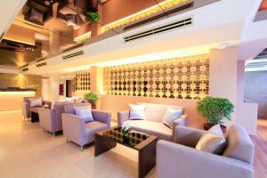 a waiting room with couches and a wall of wine bottles at Petals Inn in Bangkok
