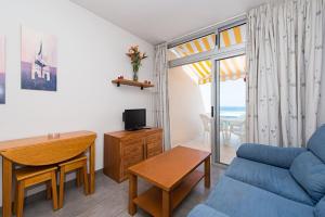 uma sala de estar com um sofá azul e uma mesa em MARSIN PLAYA 403 Vivienda Vacacional em Las Palmas de Gran Canaria