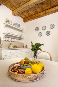un plato de fruta en una mesa de la cocina en Ammari Ortigia Apartment, en Siracusa