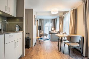 a kitchen and living room with a table and chairs at Aparthotel Adagio Lille Centre Grand Place in Lille