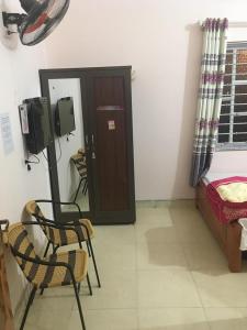 Habitación con puerta, 2 sillas y 1 cama en Lung Ho motel, en Làng Cac