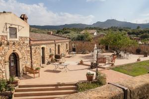 a stone building with a patio with a table and chairs at Le Querce di Cota in Troina