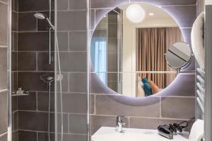 a bathroom with a sink and a mirror at Aparthotel Adagio Lille Centre Grand Place in Lille