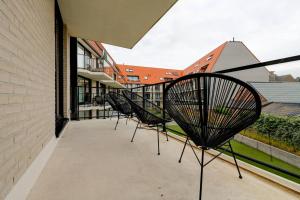 een rij stoelen op een balkon bij Jef in Nieuwpoort
