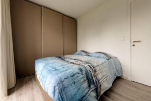 een slaapkamer met een bed en een muur bij Jef in Nieuwpoort