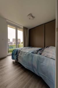 een slaapkamer met een groot bed en een groot raam bij Jef in Nieuwpoort