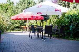 a table and chairs with umbrellas on a patio at Zajazd Pod Gwiazdami in Lublin