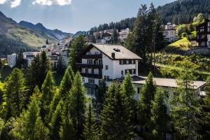 een stad in de bergen met bomen bij Belmont- Apartment Haus in Arosa