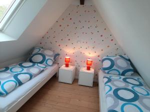 哈默爾恩的住宿－Ferienhaus Sonja，小型阁楼卧室配有两张床和红色蜡烛