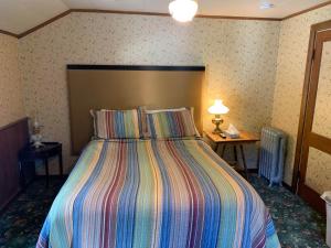 Schlafzimmer mit einem Bett mit gestreifter Decke in der Unterkunft Maple Lane Empire in Empire