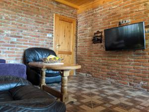 een woonkamer met een tafel en een televisie bij Luxury Apartment in Sumava National Park in Nová Pec
