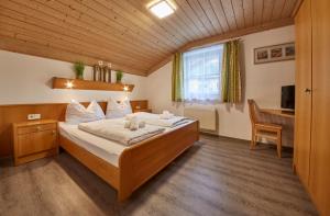 a bedroom with a bed and a desk with a computer at Appartements Living Saalbach in Saalbach Hinterglemm