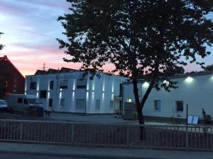 a white building with a tree in front of it at Pension Kochertal in Aalen