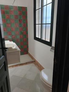a bathroom with a toilet and a window at Casa Rural El Mirador in Guadalcanal