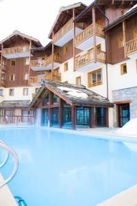 een leeg zwembad voor een gebouw bij travelski home premium - Résidence Les Alpages de Val Cenis 4 in Les Champs