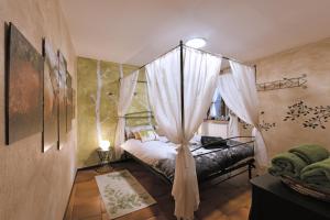 - une chambre avec un lit à baldaquin et des rideaux dans l'établissement Maison I Love Mont Blanc, à Courmayeur