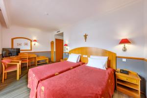 a bedroom with a bed and a desk and a television at Hotel Santo Amaro - SA Hotels in Fátima
