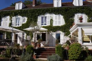 a white house covered in ivy at La Gallina Bianca in Feucherolles