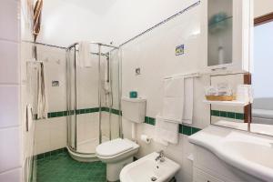 a white toilet sitting next to a bath tub in a bathroom at Hotel Orsa Maggiore in Vulcano