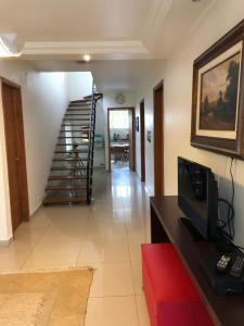 a living room with a staircase and a television at Hostel Borba Gato in Sao Paulo