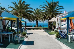 een resort met palmbomen en een strand bij Happy Camp mobile homes in Castello Camping & Summer Resort in Neos Marmaras