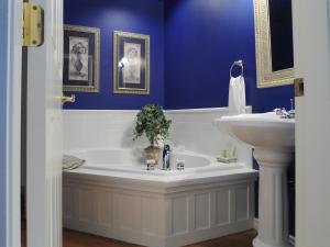 a blue bathroom with a tub and a sink at The Beacon Inn at Sidney in Sidney