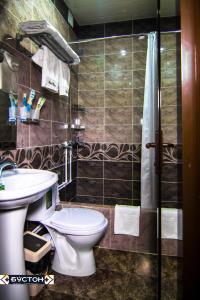 a bathroom with a toilet and a sink at Hotel Buston in Chkalovsk +74 photos