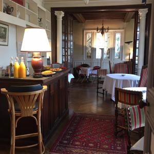 a restaurant with a bar with a table and chairs at La Villa L'Argentine in Cabourg