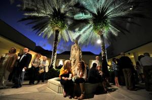 um grupo de pessoas sentadas em frente às palmeiras em Historic Cottage With Private Pool! Home em West Palm Beach