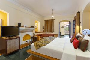 a bedroom with a large bed and a fireplace at The Haveli Hari Ganga by Leisure Hotels in Haridwār
