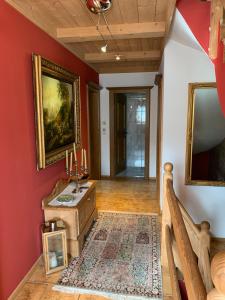 a hallway with red walls and a table with candles on it at Gästehaus Wimmer in Mittersill
