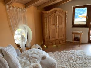 ein Schlafzimmer mit einem weißen Bett und einem großen Schrank in der Unterkunft Gästehaus Wimmer in Mittersill