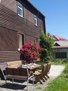 een houten tafel met banken en bloemen voor een gebouw bij Sofia House in Abertamy